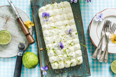 serving summer lime pie on kitchen table with flowersの写真素材