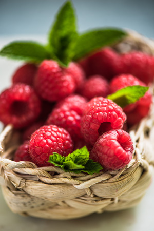 basket with fresh raspberries and mint, bright and vibrant