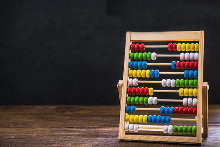 retro abacus in classroom agains black empty chalkboardの写真素材