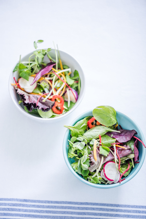 bowls with rainbow salad on white kitchen clothの写真素材