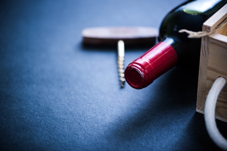 red wine bottle and wooden case in cellar with corkscrewの写真素材