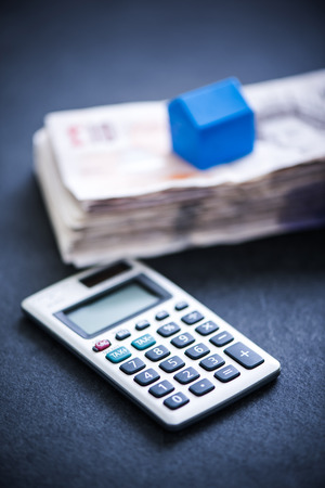 taking house mortgage, cash pile and home symbolの写真素材