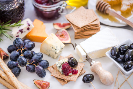 serving cheese board with wide selection of appetizersの写真素材