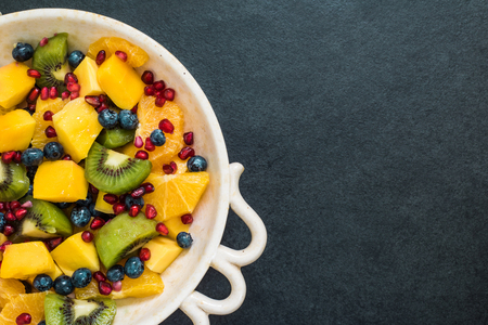 vibrant fresh exotic fruit salad on dark slateの写真素材