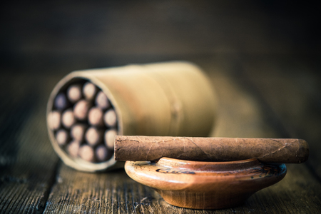 handmade cigar on wooden table, moody dark imageの写真素材