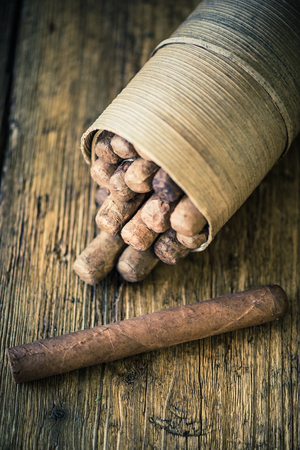 handmade cigar on wooden table, moody dark image