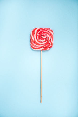 red vibrant swirl lollipop with wooden stickの写真素材