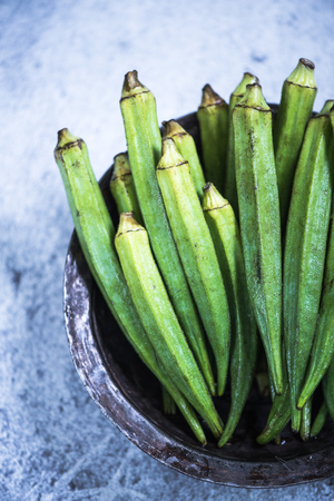 Okra in rustic bowl on slate backgroundの写真素材