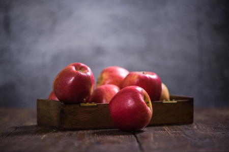Red ripe autumn apples in wooden rustic boxの写真素材