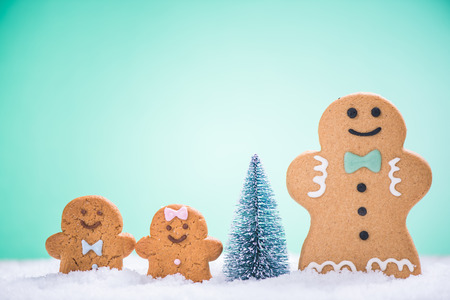 Gingerbread family decorate Christmas tree outdoor in snow
