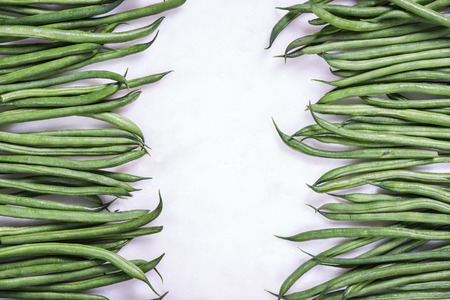 Green raw beans strings, border background on white marbleの写真素材