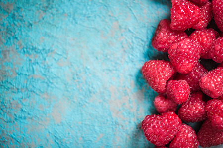Fresh raspberries border background, overhead view