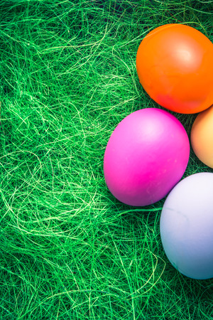 Pastel painted Easter eggs on green grassの写真素材