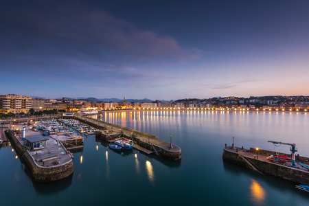 Illuminated port in San Sebastian at evening twilight in Donestia, Spain.のeditorial素材