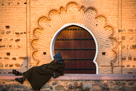 Marrakech,Morocco - January 25th 2018: Moroccan Berber in traditional clothes resting by Koutoubia Mosque.のeditorial素材