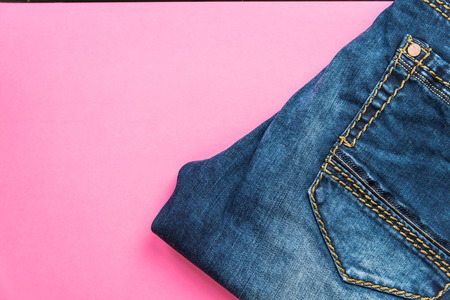 Blue jeans on pink pastel background.の写真素材
