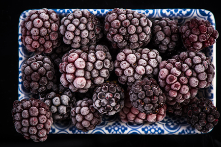 Frozen blackberry fruits, close up top view.