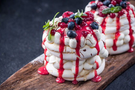 Pavlova with fresh berry fruits,mint and strawberry sauce.の写真素材