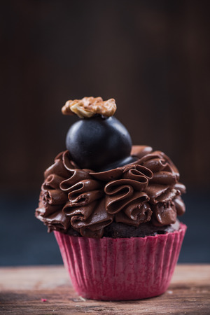 Cupcake with dark chocolate decorated with walnut.の写真素材