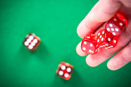 Throwing red poker dices on casino green table.の写真素材