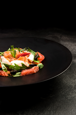 Healthy salad on dark plate.Restaurant dish,healthy eating concept.の写真素材