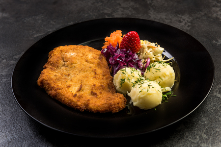 Pork meat served with potato and salad on plate.の写真素材