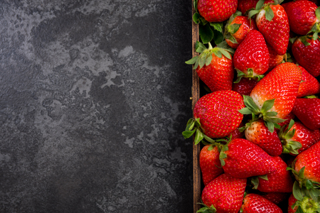 Strawberries in wooden box, border marble background.の写真素材