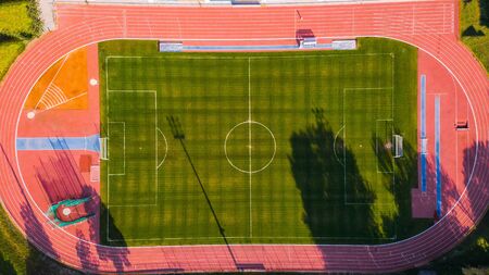 Athletic stadium and football grass pitch, aerial top down view.
