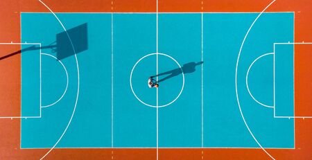 Basketball Player, Long Shadows on Basketball Court, Creative Visual Art, Aerial Image.の写真素材