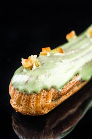 French Artisan Eclair on Black Reflective Background,Copy Space. Patisserie Bakery Product.の写真素材