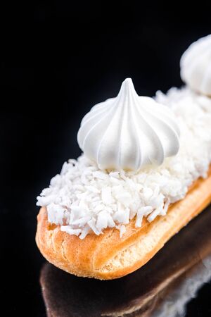 French Artisan Eclair on Black Reflective Background,Copy Space. Patisserie Bakery Product.
