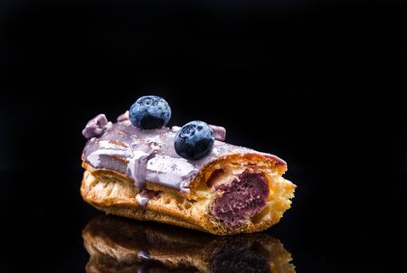 French Artisan Eclair on Black Reflective Background,Copy Space. Patisserie Bakery Product.の写真素材