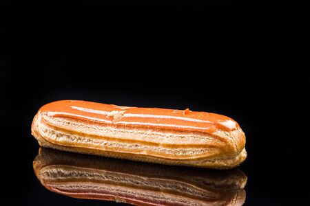 French Artisan Eclair on Black Reflective Background,Copy Space. Patisserie Bakery Product.の写真素材