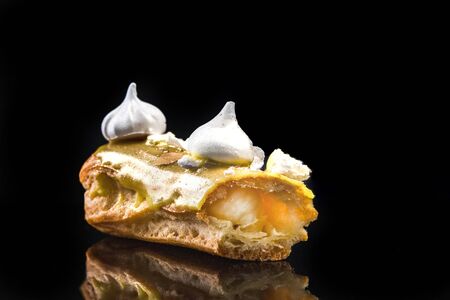 French Artisan Eclair on Black Reflective Background,Copy Space. Patisserie Bakery Product.