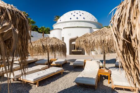 Kalithea Spring Therme Chairs on Beach with Pebbles and Bamboo Umbrella,Rhodes,Greece.の写真素材