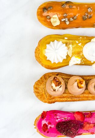 Artisan French Eclairs Decorated, Top View on White Marble Table.の写真素材