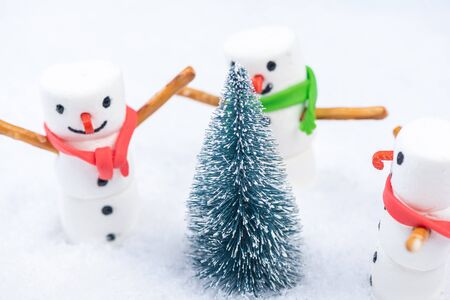 Festive Christmas Snowmans Dancing Around Christmas Tree in Snow.の写真素材