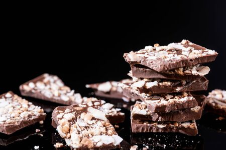 Stack of Broken Chocolate Pieces on Black Background. Copy Space. Closeup View.の写真素材