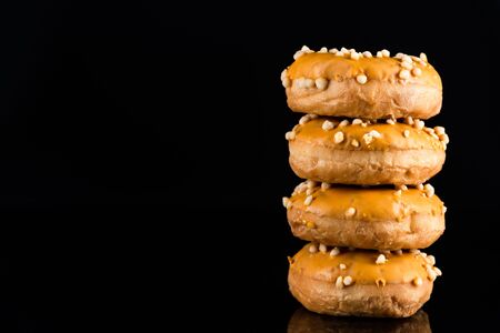 Stack of  Salted Caramel Donuts or Doughnuts on Black Background with Copy Space.