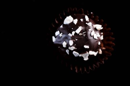 One Single Handmade Chocolate Praline Close Up View. Dark Background with Copy Space.の写真素材