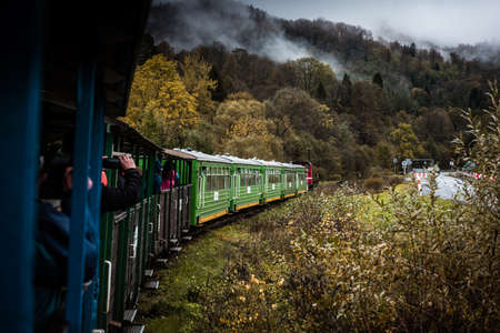 Retro Train Trough Wilderness of Bieszczady Mountains in Poland at Autumn. Dramatic Weather and Moody Toned Colors.の写真素材