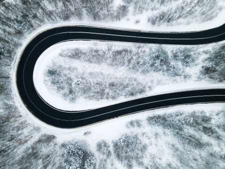 Curvy Winding Road Trough Forest at Winter Season. Aerial Drone Top Down View.の写真素材