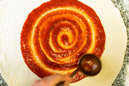 Tomato Sauce Swirl on PIzza Dough. Pizza Making.の写真素材