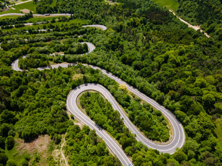 Winding Road Trough Green Forest. Aerial Drone Viewの写真素材