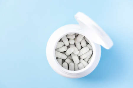 White Capsules with Medicine Drug in Whine Container Bottle.の写真素材