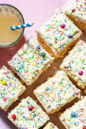 Sliced Sponge Cake DEcorated With Cream and Sprinkles. Closeup View.