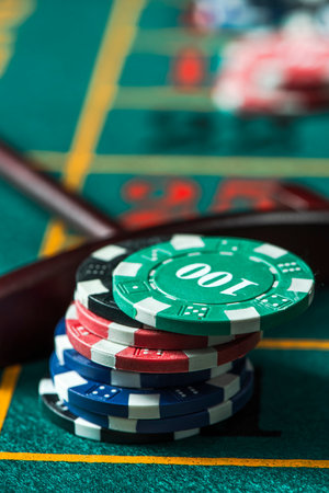Casino Roulette Chips Stack Pile on Green Poker Table.