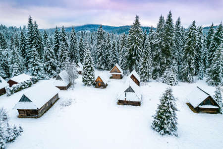 Winter Wonderland with Snow and Wooden Houses in Mountains.の写真素材