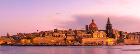 Panorama of Valletta skyline, capitol of Malta. Illuminated architecture at sunset.の写真素材
