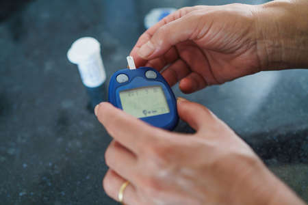 Medicine, Diabetes, Glycemia, Health care and people concept - close up of female using lancelet on...
